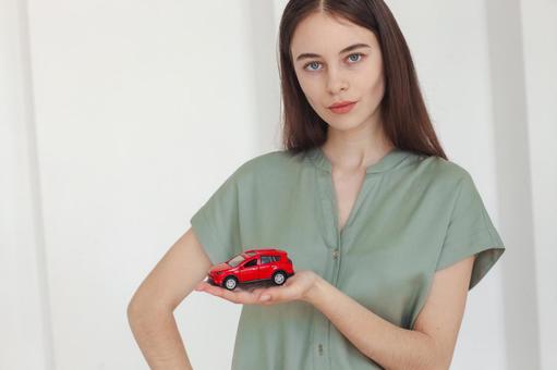 赤い車を持った女性スタッフ 保険業,事務職,接客業の写真素材