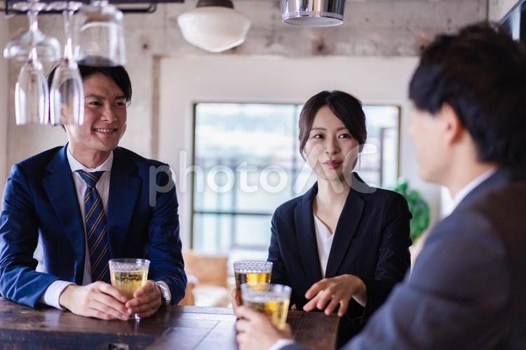 バーでお酒を飲む男女の会社員 紹介,メンバー,大人の写真素材