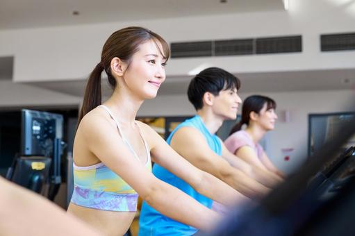 ジムでランニングする女性 トレーニング,エアロバイク,フィットネスの写真素材