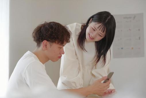 スマホで積立や貯蓄の計画を立てるカップル スマホで積立や貯蓄の計画を立てるカップル 同棲,新婚,将来設計の写真素材