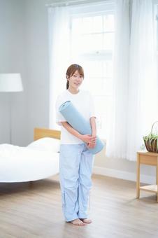 笑顔でヨガマットを持つ女性 女性,ヨガマット,持つの写真素材