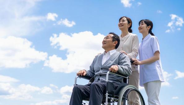 青空の下 同方向を見るシニア男性と介護士 青空の下 同方向を見るシニア男性と介護士の写真