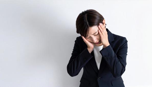 悩み考えるビジネスマンの写真