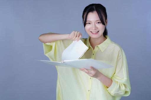 ページをやぶる黄色い服の女性 女性,ルーズリーフ,バインダーの写真素材