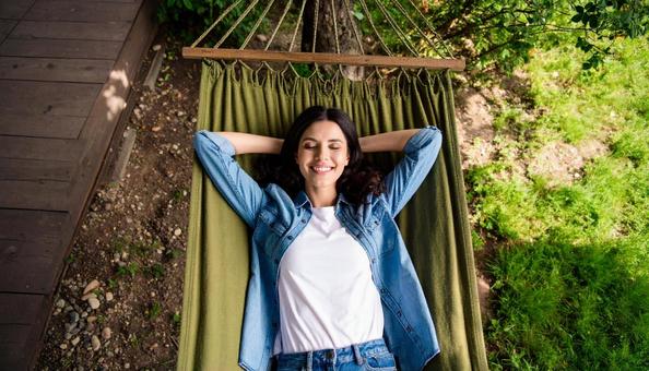 ハンモックに揺られてゆったり過ごす女性 ハンモックに揺られてゆったり過ごす女性の写真