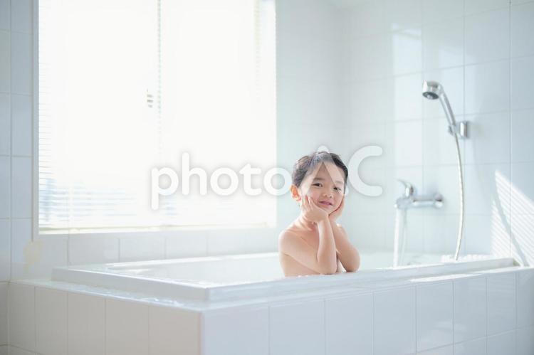 縁に肘をついてお風呂に入っている男の子 お風呂,男の子,子どもの写真素材