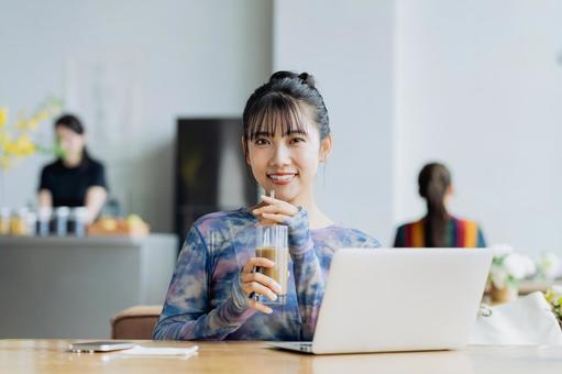 カフェで仕事をするフリーランスの若い女性 カフェで仕事をするフリーランスの若い女性の写真