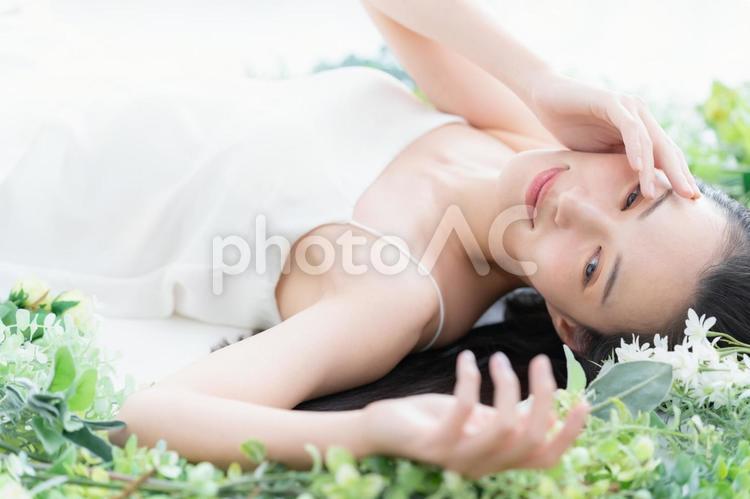 緑の中でスキンケアをする若い女性 ビューティー,女性,スキンケアの写真素材