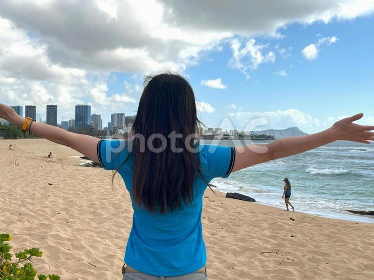 ハワイで両手を広げる女性。ポジティブ 女性の後ろ姿,大空,後ろ姿の写真素材