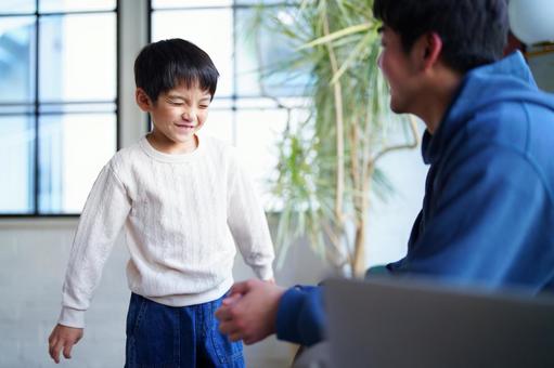 目を瞑る男の子と向かい合う男性 目を瞑る男の子と向かい合う男性 親子,男の子,小学生の写真素材