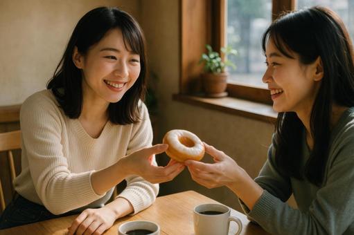 ドーナツを友人に渡す女性 ドーナツを友人に渡す女性の写真