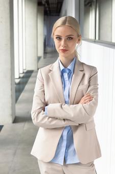 オフィスの通路で腕を組むカメラ目線のビジネスウーマン ビジネスウーマン,ビジネス,女性の写真素材