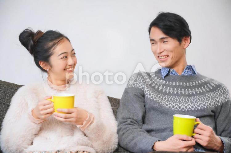 マグカップを持ってソファーに座っているカップル カップル,夫婦,男女の写真素材