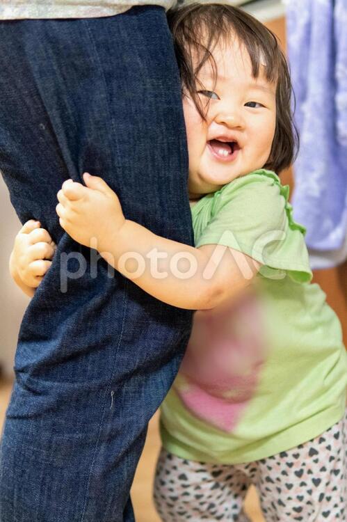 笑顔でママの足にしがみつく子供　フリー素材無料素材写真イメージ しがみつく,子供,笑顔の写真素材