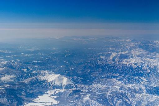 飛行機から見た冬の雪山と山脈 飛行機から見た冬の雪山と山脈の写真