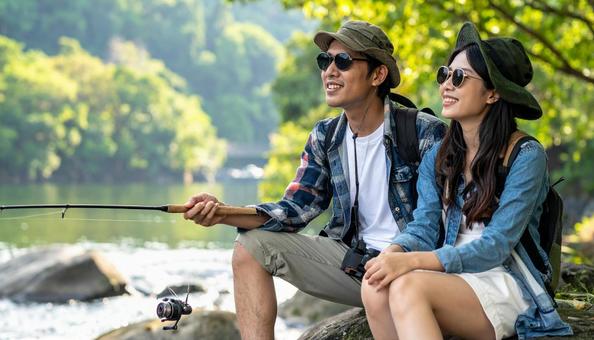 釣りをするサングラスのカップル 釣りをするサングラスのカップルの写真