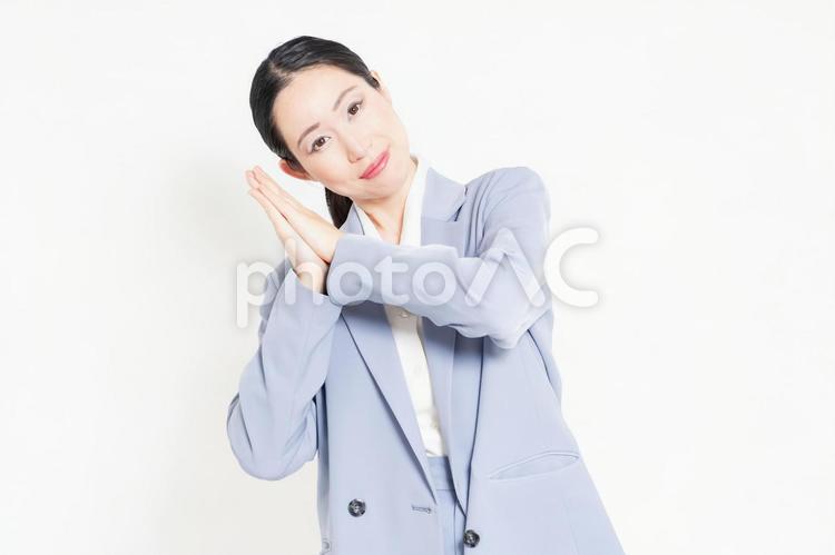白バックの前に立って、お願いのジェスチャーをする女性 お願い,祈る,頼むの写真素材