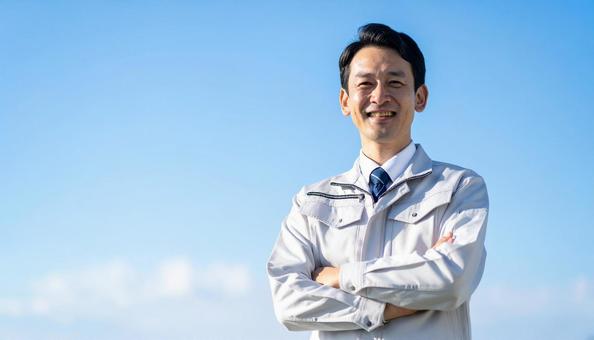 青空の下で笑顔の日本人中年男性建設作業員 青空の下で笑顔の日本人中年男性建設作業員の写真