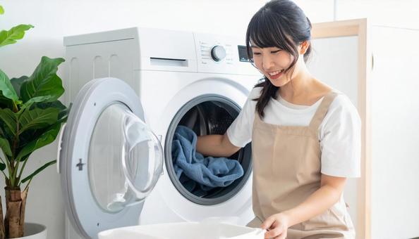 洗濯機からタオルを取り出す若い日本人女性 洗濯機からタオルを取り出す若い日本人女性の写真