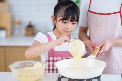 パンケーキ生地を流し込むクッキングシーン 女の子,料理,フライパンの写真素材