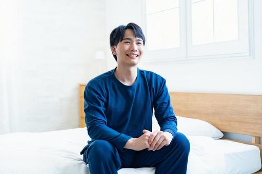ベッドで笑顔の男性 ベッドで笑顔の男性 アジア人,家,室内の写真素材