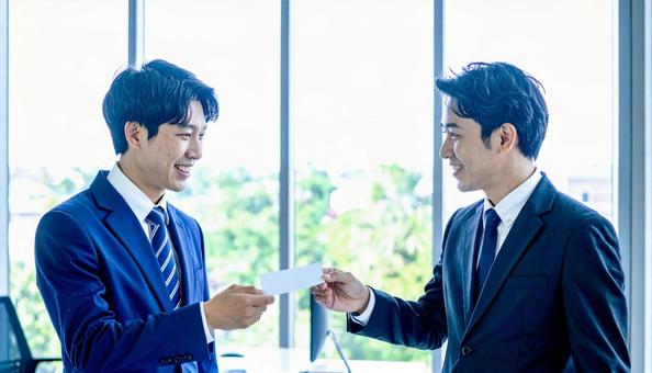 丁寧な名刺交換をする男性ビジネスパーソン 丁寧な名刺交換をする男性ビジネスパーソンの写真