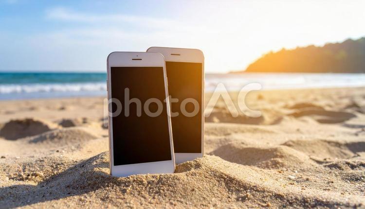 デジタルと自然の夏風景 スマホ,ビーサン,波打ち際の写真素材