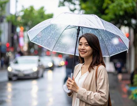 雨の日に傘をさしている若い女性 雨の日に傘をさしている若い女性の写真