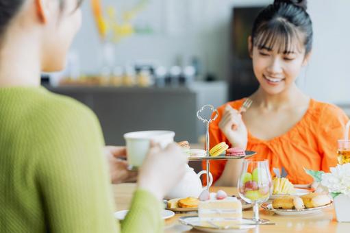 カフェでアフタヌーンティーをする若い女性 カフェでアフタヌーンティーをする若い女性の写真