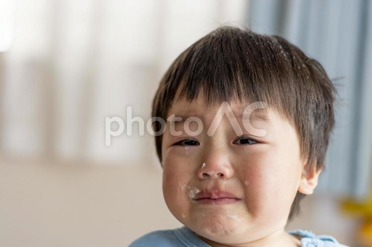 お菓子作り中に泣く子供の顔（男の子、2歳 男の子,泣く,泣き顔の写真素材