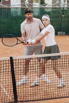 ラケットを持って指導を受ける女性の写真