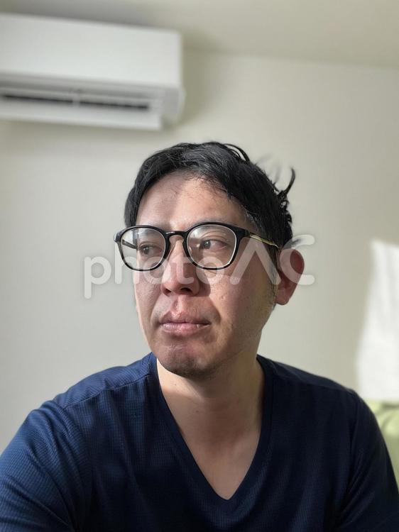 部屋で呆然とする男性　2 メガネ,男性,たたずむの写真素材