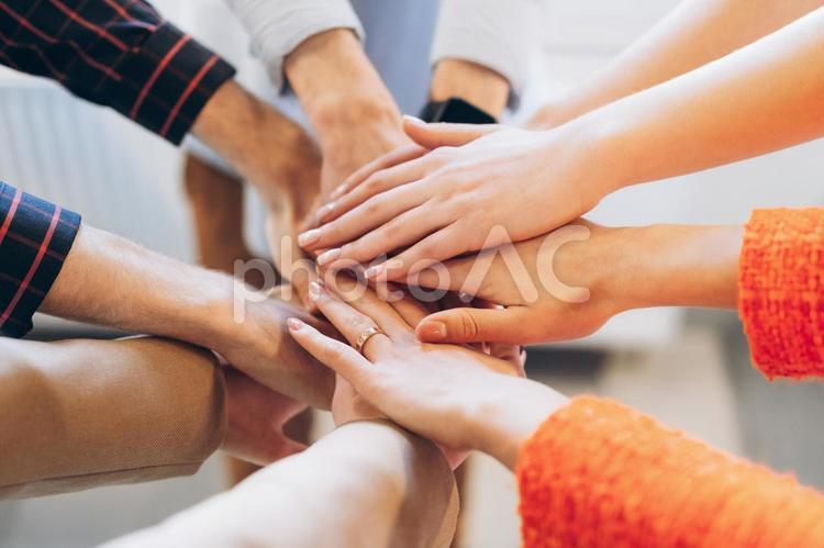 オフィスで手を重ねる男女 ビジネス,ビジネスマン,ビジネスウーマンの写真素材