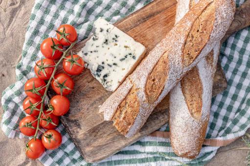 カッティングボードの上のトマトやパン ミニトマト,ブルーチーズ,フランスパンの写真素材