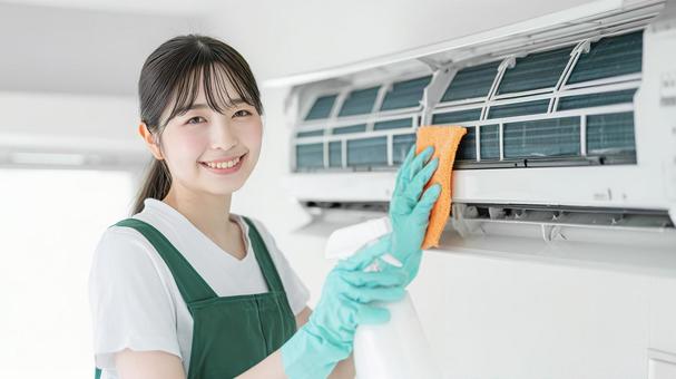 笑顔の女性作業員のエアコンクリーニング 笑顔の女性作業員のエアコンクリーニングの写真