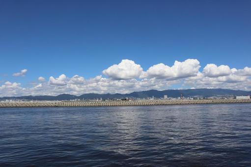 海とテトラポットの波除と街と山と雲と青空 海とテトラポットの波除と街と山と雲と青空 青い,海,波の写真素材