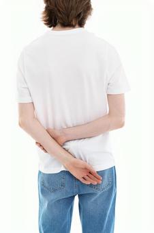 右手で左腕を掴む人の後ろ姿 右手で左腕を掴む人の後ろ姿の写真