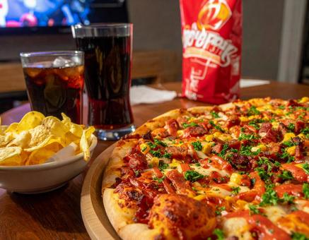 ピザとコーラで楽しむ食卓の写真