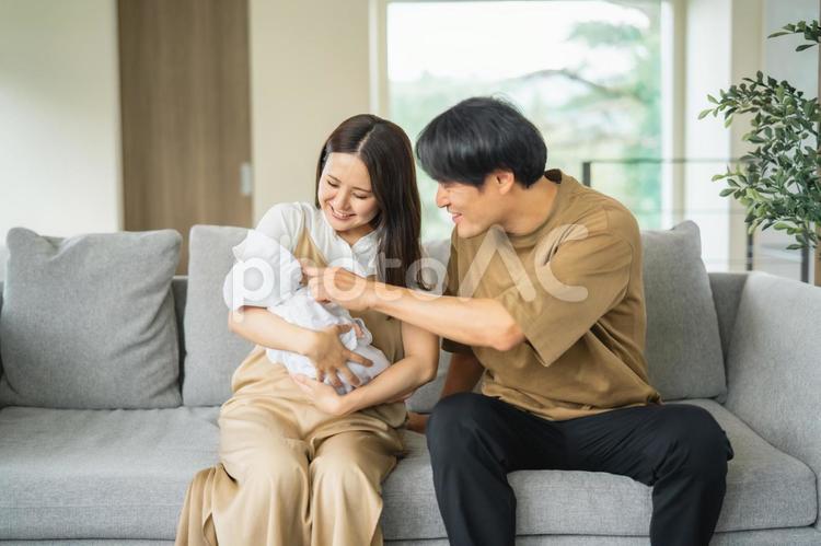 ソファで赤ちゃんを抱く男女 赤ちゃん,育児,新婚の写真素材
