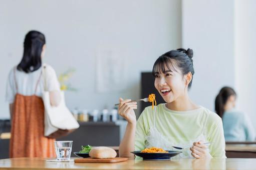 カフェでランチを食べる若い女性 カフェでランチを食べる若い女性 食事,ランチ,カフェの写真素材