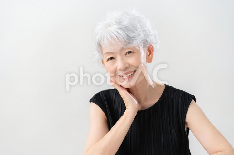 白バックでスキンケアをするシニアの女性 ビューティー,女性,シニアの写真素材