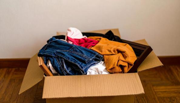 段ボール箱に入れた衣類と本と額縁 段ボール箱に入れた衣類と本と額縁の写真