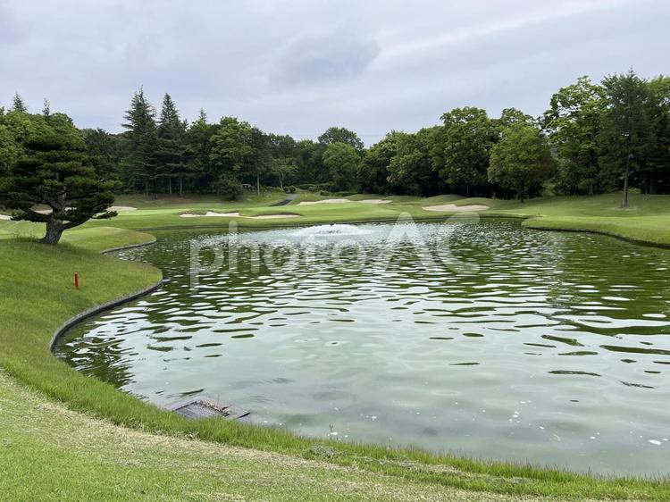 ゴルフ場の池とグリーンの風景 ゴルフ,ゴルフ場,ゴルフコースの写真素材