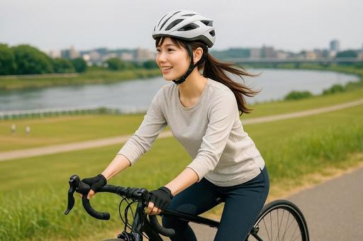 川沿いをサイクリングする女性 川沿いをサイクリングする女性の写真