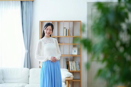 カメラ目線で笑う青いスカートの女性 女性,笑う,笑顔の写真素材