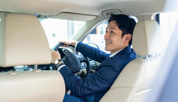 ハンドルを握りタクシーを運転する男性 ハンドルを握りタクシーを運転する男性の写真