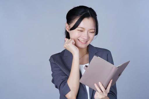 グレーの服の女性が書類を読む 女性,微笑む,嬉しいの写真素材