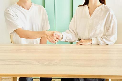 正面で握手する男性と女性 正面で握手する男性と女性の写真