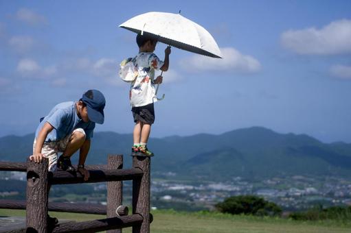 <素材>山の上で仲良く遊ぶ家族旅行の兄弟 <素材>山の上で仲良く遊ぶ家族旅行の兄弟 子供,青空,男の子の写真素材