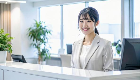 笑顔で対応する女性の受付嬢 笑顔で対応する女性の受付嬢の写真